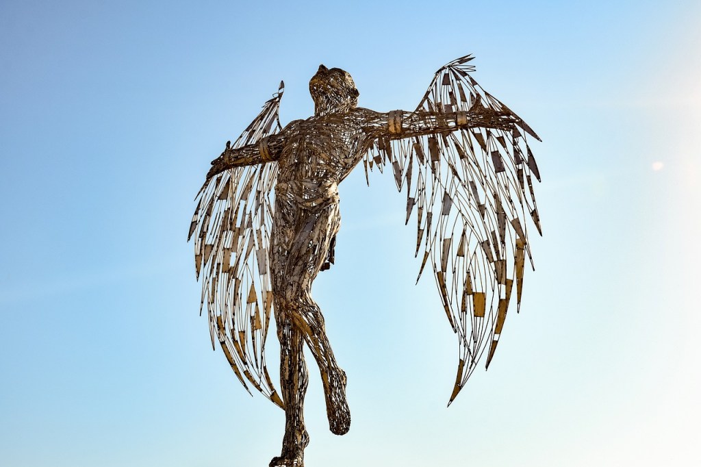 A sculpture of Icarus by Panikkos Spanos - Icarus stands as if about to launch himself in flight, his wings made of feathers spread wide.
